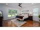 Bright bedroom with shiplap accent wall, ceiling fan, natural light, hardwood floors, and bench at 4143 Willow Haven Dr, Denver, NC 28037