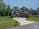 Stately brick home with a spacious driveway and manicured landscaping, showcasing curb appeal at 4143 Willow Haven Dr, Denver, NC 28037