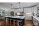 Bright kitchen with white cabinetry, stainless steel appliances, a spacious island, and hardwood flooring at 4143 Willow Haven Dr, Denver, NC 28037