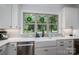 Well-lit kitchen sink area with a garden view window with wreaths and stainless steel appliances at 4143 Willow Haven Dr, Denver, NC 28037