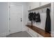 Mudroom with patterned floors, white storage cabinets, bench, and coat hooks near the home's entry at 4143 Willow Haven Dr, Denver, NC 28037