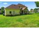 Expansive backyard with lush green grass, patio, and yellow siding on the house at 4499 Briarcreek Rd, Maiden, NC 28650