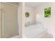 Bright bathroom featuring a shower, a tub with tile surround, and octagon window at 4499 Briarcreek Rd, Maiden, NC 28650