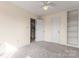 A spacious bedroom with plush carpet, ceiling fan, built-in shelves, and an open doorway at 4499 Briarcreek Rd, Maiden, NC 28650