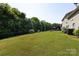 A large, well-maintained backyard features a lush lawn, mature trees, and a private patio area perfect for entertaining at 4683 Dunberry Sw Pl, Concord, NC 28027