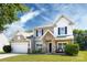 Charming two-story home with a stone porch and a well-manicured lawn under a beautiful blue sky at 4683 Dunberry Sw Pl, Concord, NC 28027