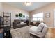 Comfortable living room featuring a plush sofa, a cozy chair, and a large window, creating a relaxing ambiance at 4683 Dunberry Sw Pl, Concord, NC 28027