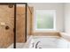 Elegant bathroom with a glass-enclosed shower, tub, and a window with frosted glass at 4848 Fonthill Ln, Charlotte, NC 28210
