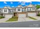 Lovely exterior townhome showing brick details, a two-car garage, manicured lawn, and inviting entrance at 4848 Fonthill Ln, Charlotte, NC 28210
