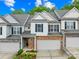 Charming townhome with a two-car garage and brick facade, complemented by beautiful landscaping at 4848 Fonthill Ln, Charlotte, NC 28210