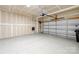 Spacious garage with epoxy flooring, paneled walls, and an automatic garage door at 4848 Fonthill Ln, Charlotte, NC 28210