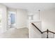 Upstairs hallway with neutral carpeting and an open view to other rooms at 4848 Fonthill Ln, Charlotte, NC 28210