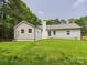 Spacious backyard featuring a lush lawn and a charming home exterior with a gray roof at 4905 Chestnut Lake Dr, Charlotte, NC 28227