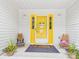 Inviting front porch featuring a bright yellow door, wooden chairs, and potted plants at 4905 Chestnut Lake Dr, Charlotte, NC 28227