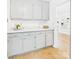 Well-lit kitchen featuring neutral-toned cabinets, quartz countertops, and wood-look floors with bright natural light at 4905 Chestnut Lake Dr, Charlotte, NC 28227