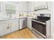 Cozy kitchen featuring stainless steel appliances, bright white cabinets, and a charming window above the sink at 4905 Chestnut Lake Dr, Charlotte, NC 28227