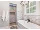 Bathroom featuring a modern tub, hexagon tile flooring, and walk-in shower with window at 5215 Star Magnolia Ct, Clover, SC 29710