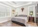 Serene bedroom with a tray ceiling, two windows, and an accent wall with a unique decoration at 5215 Star Magnolia Ct, Clover, SC 29710