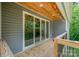Inviting covered deck featuring a wood ceiling, string lights, and view of green trees at 5215 Star Magnolia Ct, Clover, SC 29710