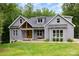 Charming grey two-story home with a wooden door, front porch swing, and a well-manicured lawn at 5215 Star Magnolia Ct, Clover, SC 29710