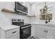 Modern kitchen features stainless steel appliances, white cabinets, floating shelves, and a window overlooking the outdoors at 5520 Chestnut Dr, Hickory, NC 28602