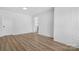 Open living room with white-painted brick wall and wood-look floors at 5520 Chestnut Dr, Hickory, NC 28602