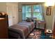 Bright bedroom with a single bed, ample storage space, and a large window that illuminates the room at 5806 Whitingham Dr, Charlotte, NC 28215