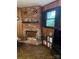Cozy living room with brick fireplace, wood paneling, and a shelf displaying decorative items at 5806 Whitingham Dr, Charlotte, NC 28215