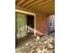 Covered patio with brick walls and sliding door, offering a shaded outdoor space at 5806 Whitingham Dr, Charlotte, NC 28215