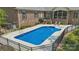 Bright blue backyard pool features a black metal fence, lounge chairs and tasteful landscaping at 5812 Morgan Park Dr, Monroe, NC 28110