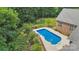 Aerial view of a fenced pool surrounded by trees and a well-manicured lawn at 5812 Morgan Park Dr, Monroe, NC 28110