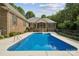 A sparkling blue pool with a concrete patio, surrounded by a fence and lush landscaping at 5812 Morgan Park Dr, Monroe, NC 28110