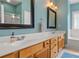 Well-lit bathroom featuring double sinks, wood cabinets, and framed mirrors at 6129 Caseys Side Way, Fort Mill, SC 29708