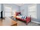 Light blue bedroom with a red bed, desk, and natural light at 6129 Caseys Side Way, Fort Mill, SC 29708