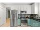 Updated kitchen featuring stainless steel appliances, a stylish backsplash, and custom blue cabinets at 6129 Caseys Side Way, Fort Mill, SC 29708