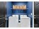Well-lit laundry room with a washer and dryer set with storage shelves above at 6261 Six String Ct, Fort Mill, SC 29708