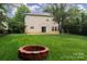 Home's backyard features lush lawn, fire pit and patio area, ideal for outdoor gatherings at 6914 Evanton Loch Rd, Charlotte, NC 28278