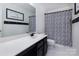 Modern bathroom featuring a sleek vanity with a white countertop and a stylish patterned shower curtain at 6914 Evanton Loch Rd, Charlotte, NC 28278