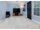 Cozy bedroom with light walls, plush carpet, and large window offering natural light at 6914 Evanton Loch Rd, Charlotte, NC 28278