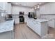 Bright kitchen featuring white cabinets, a marble island, stainless steel appliances, and modern lighting fixtures at 6914 Evanton Loch Rd, Charlotte, NC 28278