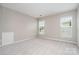 Bright bedroom featuring neutral walls, plush carpeting, and two windows for natural light at 6922 Cascade Dream Ct, Huntersville, NC 28078