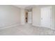 Inviting bedroom featuring carpeting, neutral walls, and a doorway that leads to the home's staircase at 6922 Cascade Dream Ct, Huntersville, NC 28078