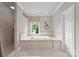 Bright bathroom featuring a soaking tub, window and tiled walk-in shower at 7412 Sahalee Dr, Denver, NC 28037