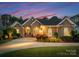 Beautiful exterior elevation of a brick and stone home with professional landscaping and warm lighting at 7412 Sahalee Dr, Denver, NC 28037