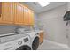 Bright laundry room featuring a sink, storage cabinets and front loading washer and dryer at 7412 Sahalee Dr, Denver, NC 28037