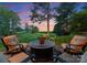 Relax on the stone patio with comfortable seating and views of the lush green golf course at sunset at 7412 Sahalee Dr, Denver, NC 28037