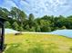 Expansive backyard boasts a lush lawn, secure white fence, fire pit, and shady trees, creating a serene retreat at 750 Fraternity Row, Kannapolis, NC 28081