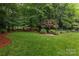 Lush backyard garden featuring mature trees and meticulous landscaping at 8008 Alba Ct, Charlotte, NC 28269