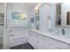Bright bathroom features double sinks with white cabinets, tub, and large window at 8008 Alba Ct, Charlotte, NC 28269