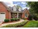 Charming brick home with dormer windows, well-manicured landscaping, and a welcoming front porch at 8008 Alba Ct, Charlotte, NC 28269